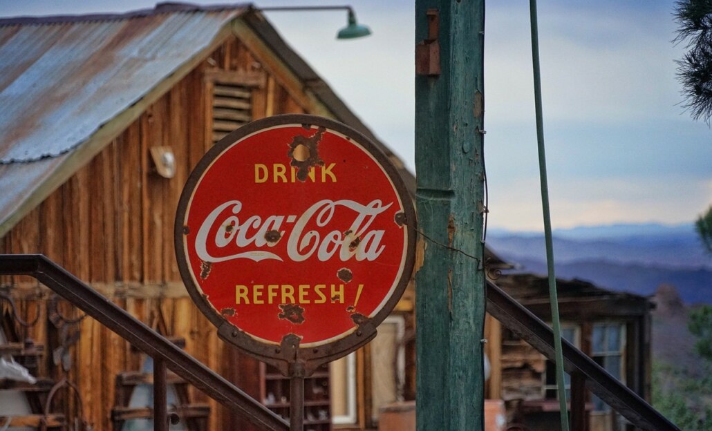 Altes Coca-Cola-Werbeschild vor verfallener Hütte